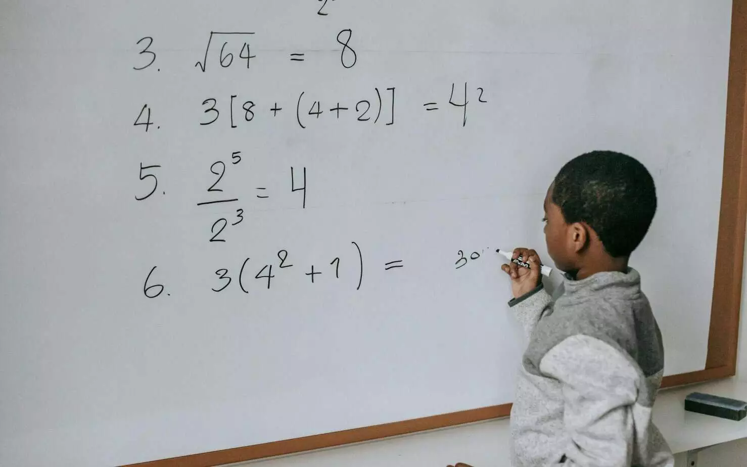 Photo by Katerina Holmes: student solving math problems